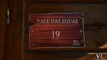 Una puerta de madera con un cartel que dice 'VALE DAS EGUAS 19' y el logotipo 'VALE DO ROSSIM' en la parte inferior.