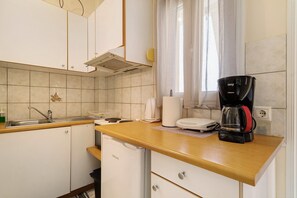 A kitchen with a sink, stove, and a coffee maker.
