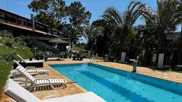 A swimming pool with lounge chairs and a stone deck.