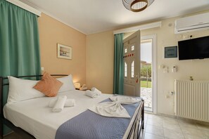 Ein Hotelzimmer mit Bett, Fernseher und Blick nach draußen.