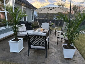 Eine Terrassengruppe mit Tisch, Stühlen und Topfpflanzen.
