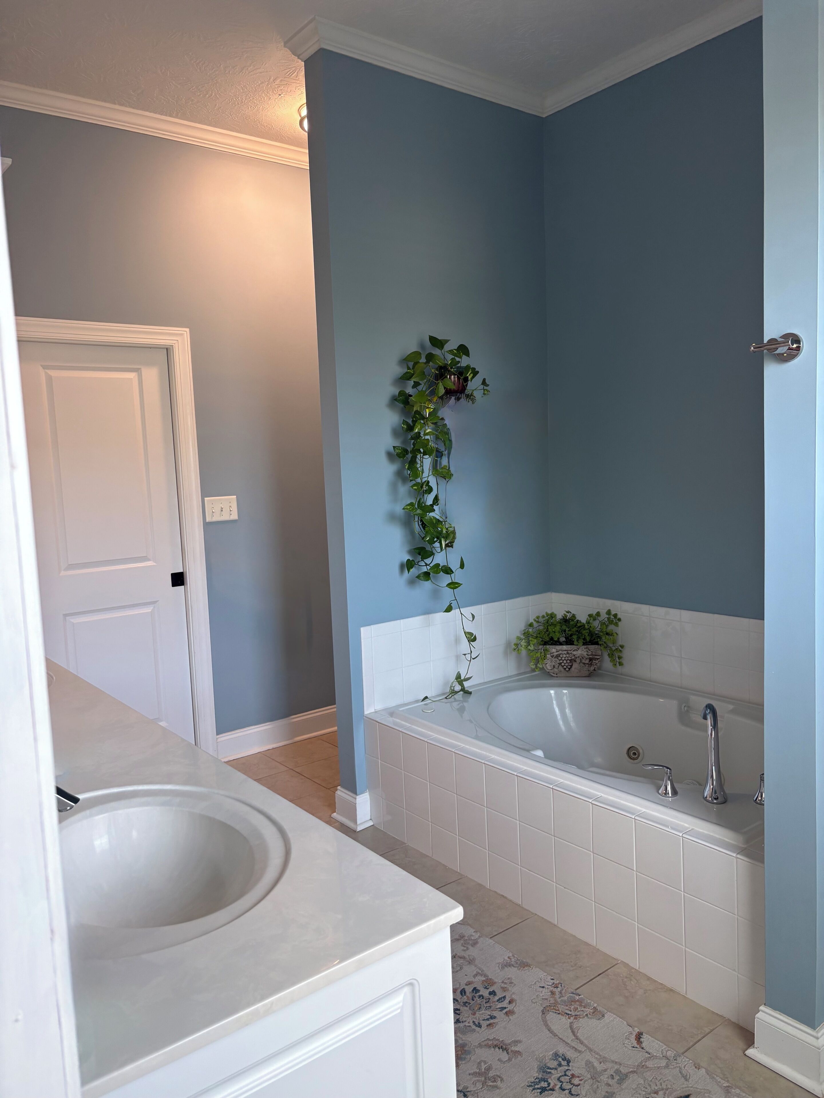A bathroom with a bathtub, a sink, and a door.