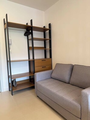A room with a sofa, a wooden shelf unit with drawers, and a telephone. - Studio Cristo Redentor (Rio de Janeiro)
