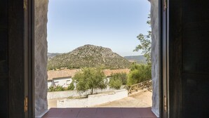 A view through a doorway of a mountainous landscape with buildings in the foreground. - Hostal Posada El Parral – Private Pool and Restaurant in the Sierra de Cádiz (Benaocaz)