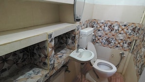 A small bathroom with a toilet, sink, and mirror.