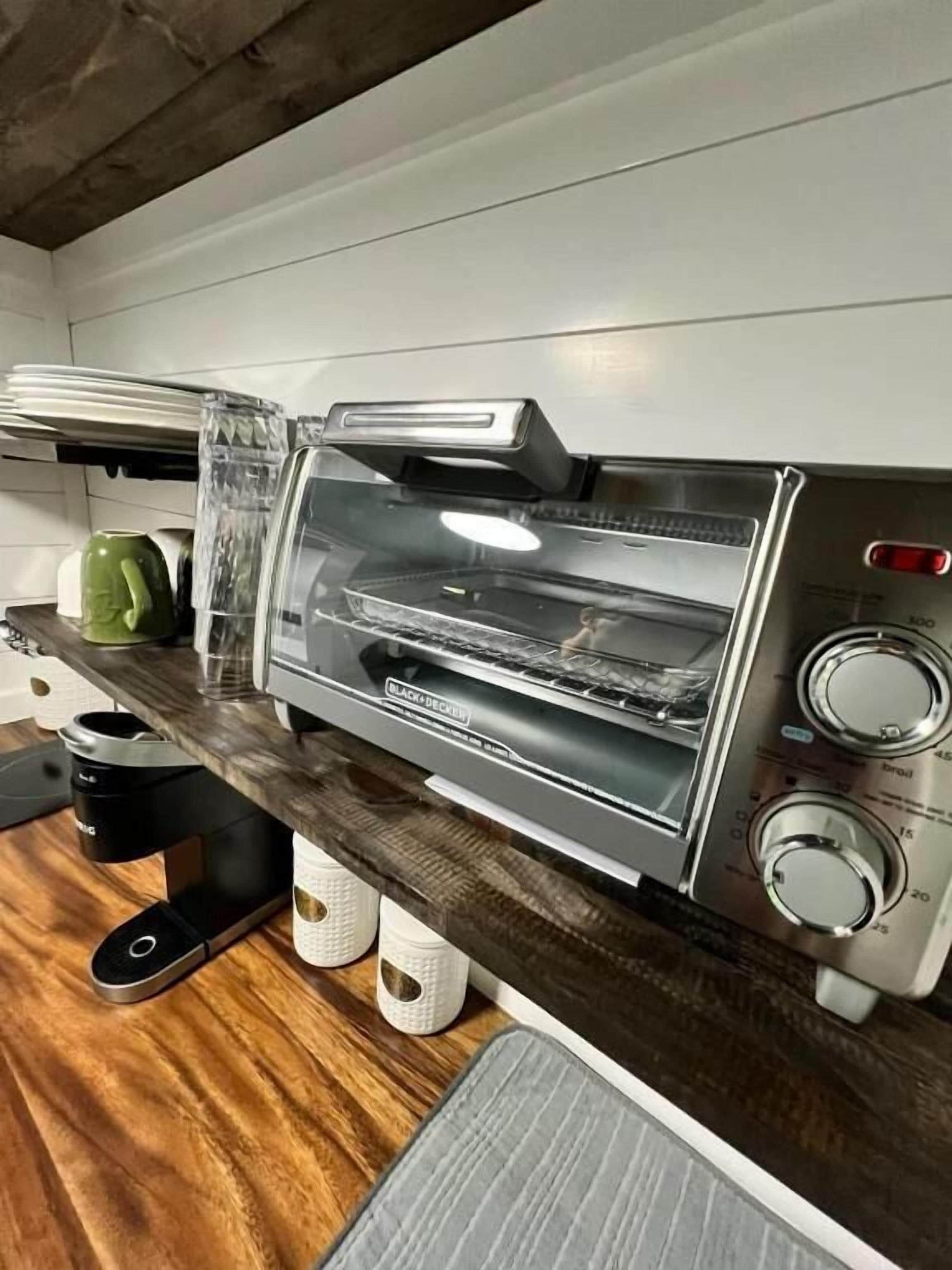 A kitchen with a built-in toaster oven, a coffee machine, and a kettle.