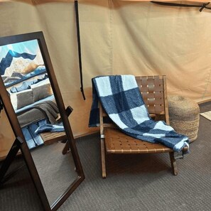A room with a wooden chair, a framed painting, and a woven basket. - Wilderness Cove Campground (Saluda)