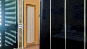 A room with a sliding door, a white door, and a dark sliding closet. - Camera con Ingresso Indipendente (Agropoli)
