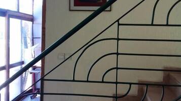 A staircase with a metal railing, a door leading outside, and a framed picture on the wall.