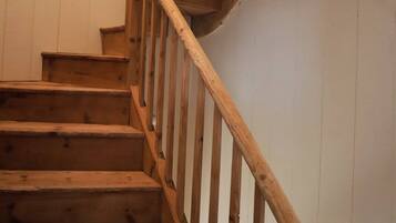 Una escalera de madera con barandilla que conduce a un piso superior.