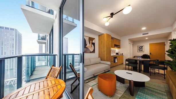 A modern apartment with a balcony, a dining area, a living room, and a kitchen. - 28th-Floor Condo in Miami Worldcenter (Miami)