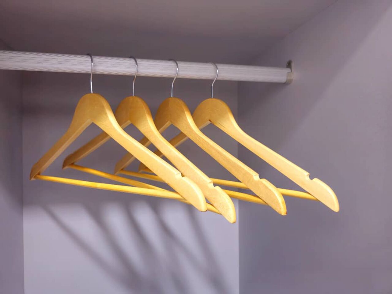 Un armadio con grucce in legno su un'asta.