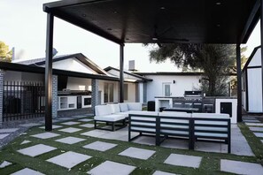 A covered outdoor patio with a grill, seating, and a view of the backyard. - Private Pool Family Home Huge Backyard & Parking (Gilbert)