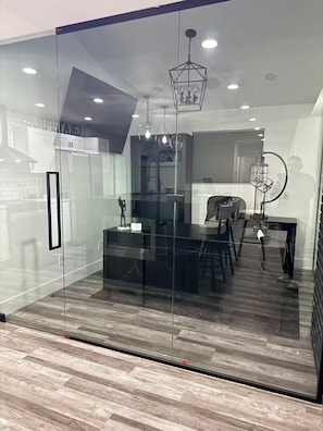 A modern kitchen with a glass partition, wooden flooring, and contemporary lighting fixtures. - Private Pool Family Home Huge Backyard & Parking (Gilbert)