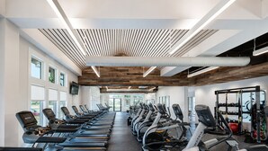 Ein Fitnessstudio mit Laufbändern, Crosstrainern und Kraftgeräten.