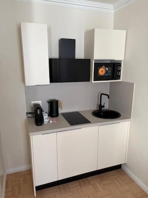 Kylskåp, mikrovågsugn, spishäll och grytor/köksredskap