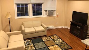Un salon avec un canapé, un téléviseur et un ventilateur de plafond.
