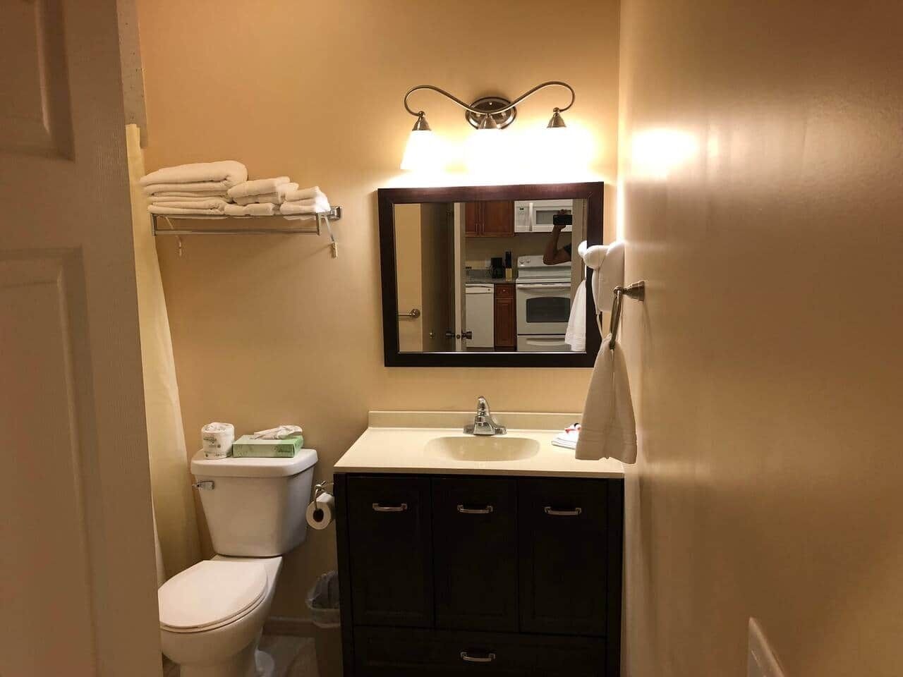 Ein Badezimmer mit Toilette, Waschbecken, Spiegel und Handtuchhalter.