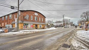 A brick building with a storefront, a pedestrian crossing sign, and a street with snow.