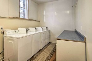 Una sala de lavandería con lavadora, secadora y una pequeña encimera.
