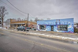 Una calle con un edificio que dice 'BREWERY' y otro edificio con un mural colorido.