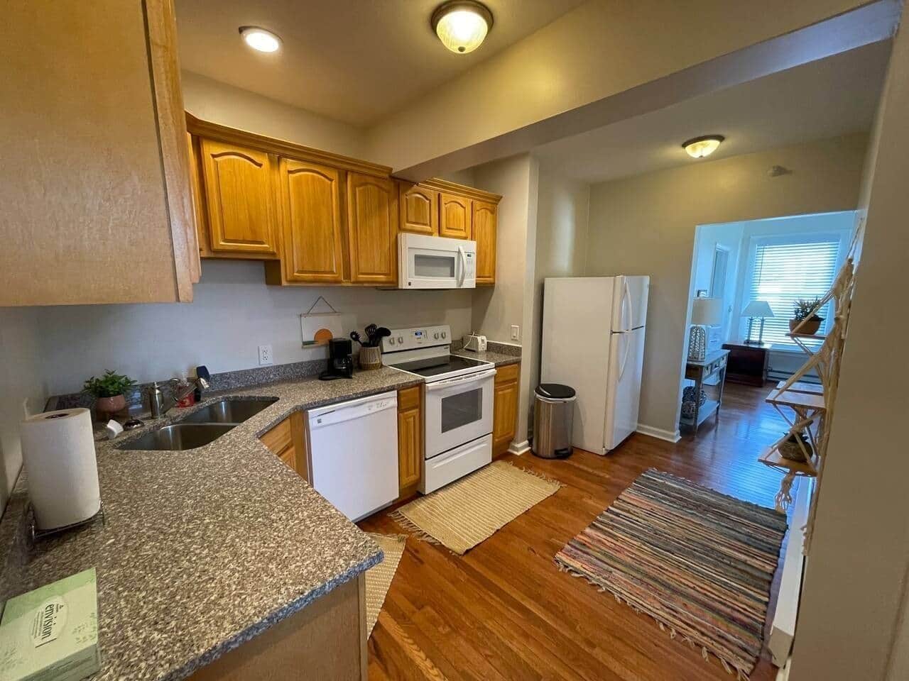 A kitchen with wooden cabinets, a microwave, a stove, and a dishwasher.