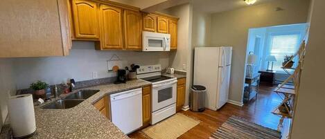 A kitchen with wooden cabinets, a microwave, a stove, and a dishwasher.