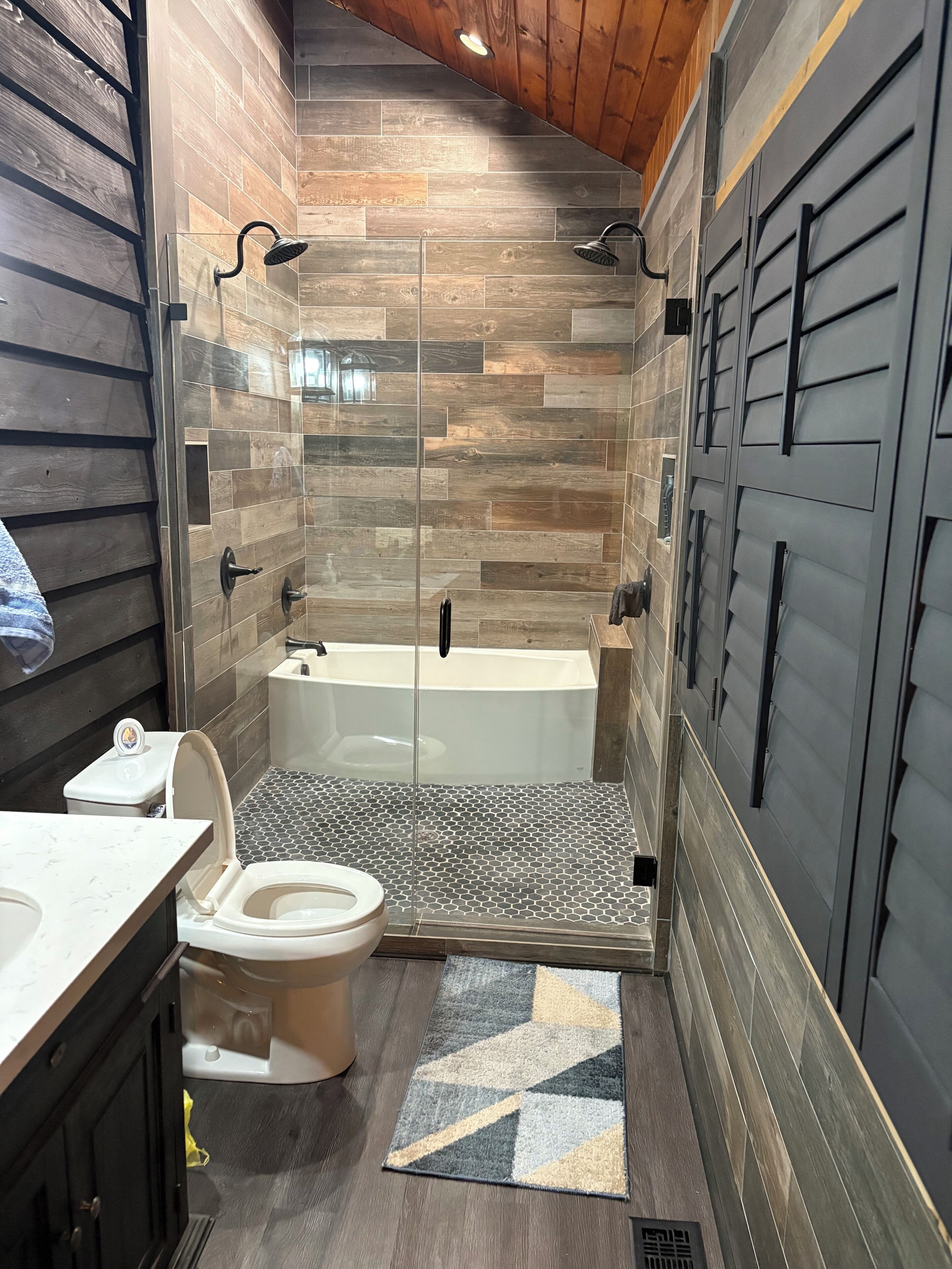 Une salle de bain moderne équipée d’une douche, de toilettes et d’une baignoire.