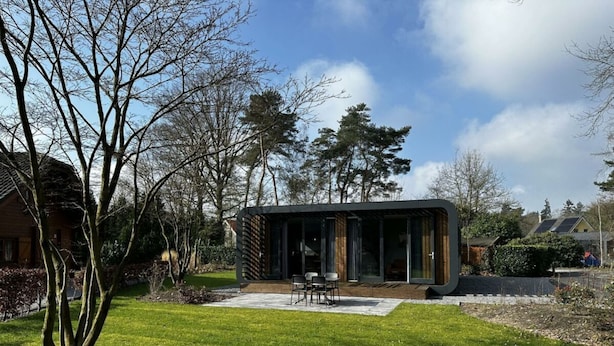 A modern house with a patio, a lawn, and surrounding trees. - Holiday Home in Lochem With Terrace (Lochem)