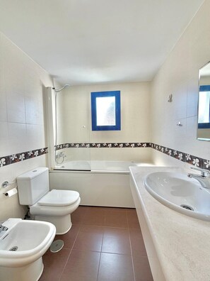 A bathroom with a toilet, bidet, bathtub, and two sinks. - Terrasol Costaluz Torre del Mar (Torre del Mar)
