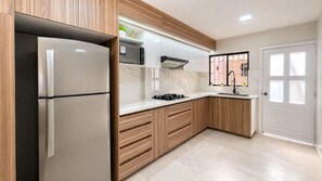 Une cuisine moderne équipée d’un réfrigérateur, d’un four à micro-ondes, d’une cuisinière et d’un évier.