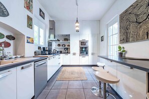 A modern kitchen with white cabinetry, a built-in oven, and a coffee machine. - Manor villa with pool 14 guests near capendu (Capendu)