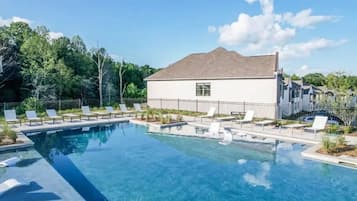 Resort-style pool with loungers and a relaxing in-water sun shelf