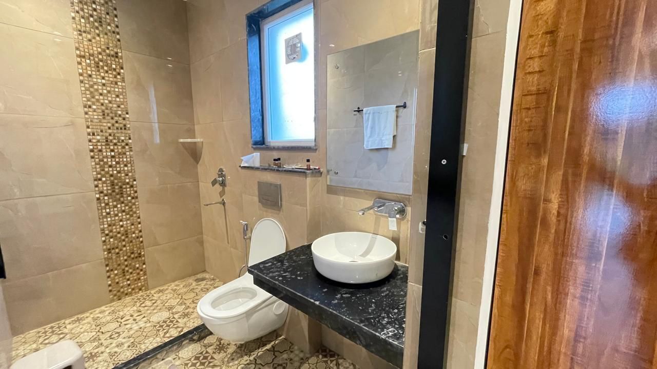 A modern bathroom with a toilet, sink, and shower.