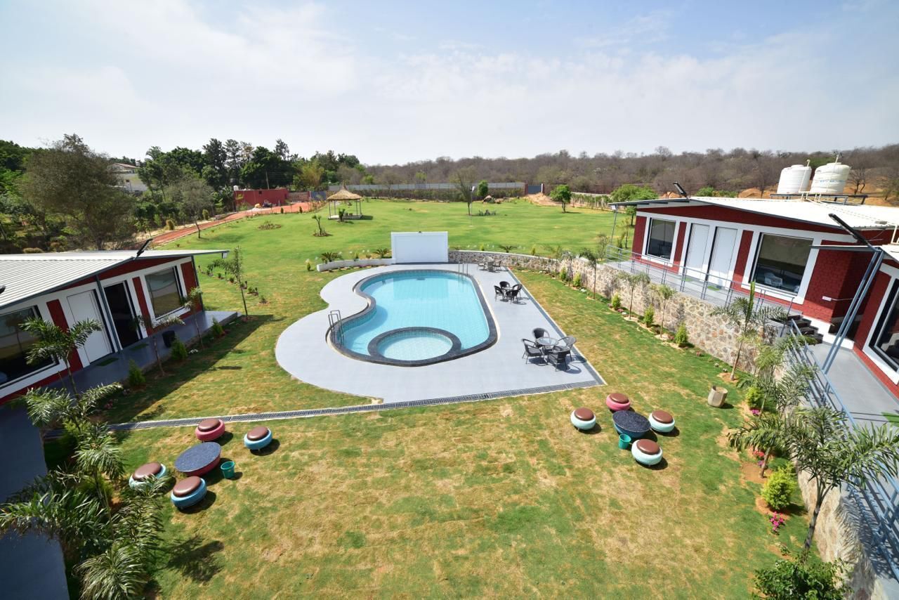 Una piscina de borde curvo, rodeada por un césped y una zona de estar.