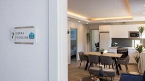 Un appartement moderne comprenant un coin repas, une cuisine et un espace de vie.