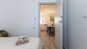 Une chambre d’hôtel comprenant un lit, un bureau et une chaise dans la pièce adjacente.