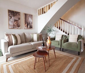 A living room with a sofa, a coffee table, and a staircase. - Beautiful Andalusian Casa in stunning Nerja a short walk to Burriana and town (Nerja)
