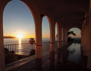 A covered walkway with arches, a railing, and a view of the sunset over the water. - Beautiful Andalusian Casa in stunning Nerja a short walk to Burriana and town (Nerja)