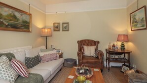 Ein Wohnzimmer mit einer Couch, einem Sessel und einem Tisch mit Dekoration.