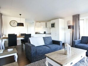 Ein modernes Wohnzimmer mit einer Couch, einem Couchtisch und einem Essbereich mit Stühlen und einem Tisch.