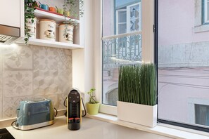 A kitchen with a toaster, a coffee maker, and a potted plant. - Rossio Boutique Apartment 2 (Lisbon)