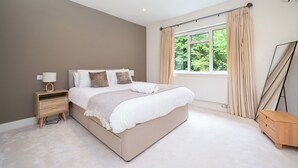 A bedroom with a bed, bedside table, lamp, and curtains. - Willow Lodge 5,800 SQFT Quiet Luxury Living - Pass the Keys (Elstree)