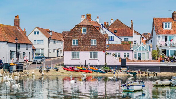 A waterfront property with traditional architecture, a dock with boats, and a calm water body. - Stunning Emsworth Family Home - Pass the Keys (Emsworth)