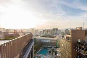 A high-rise building with a rooftop pool, a view of the cityscape, and a sign for Allianz Bank. - Studio Perdizes (São Paulo)
