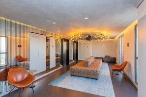 A modern hotel lobby with a central seating area, a chandelier, and a glass partition wall. - Studio Perdizes (São Paulo)