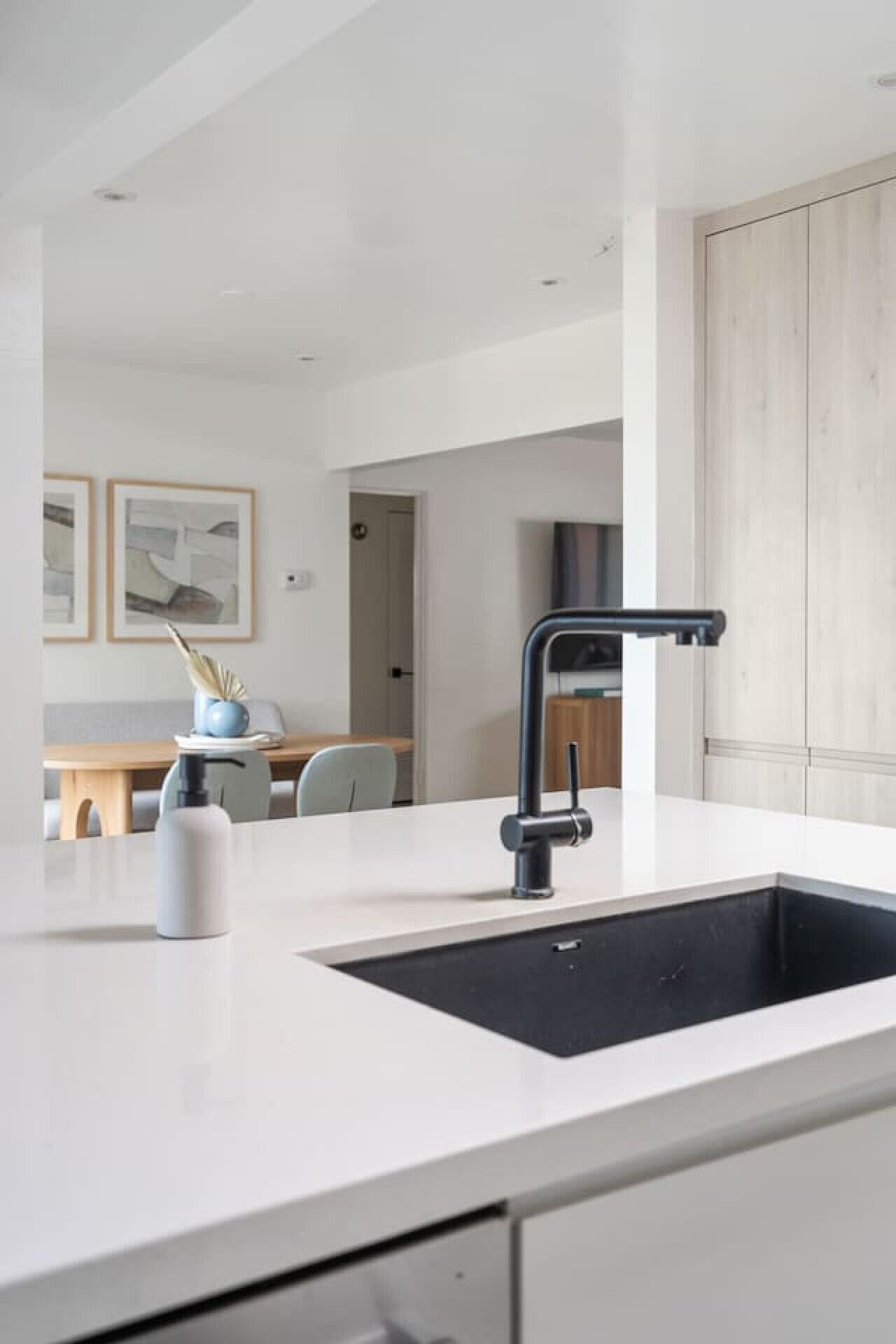 Una cocina moderna con una isla central, un lavamanos negro y un diseño minimalista.