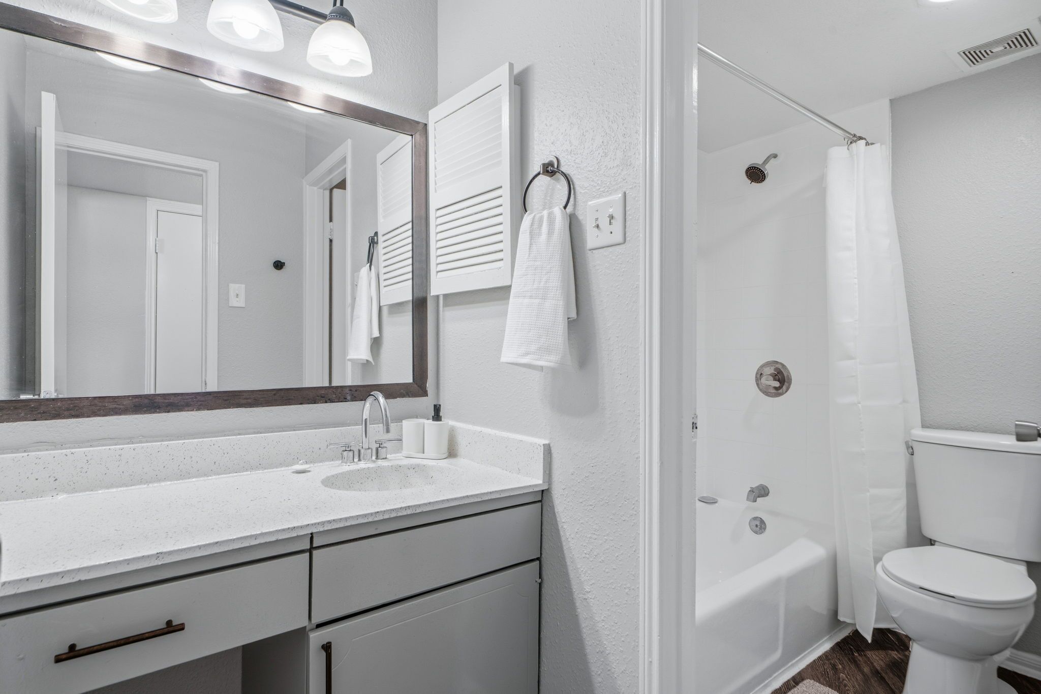 Une salle de bain avec un lavabo blanc, un miroir et un porte-serviettes.
