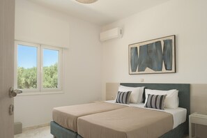 Ein Schlafzimmer mit zwei Betten, einem Fenster, einer Klimaanlage und einem Bild an der Wand.