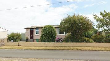 A residential house with a front yard, a driveway, and a street.